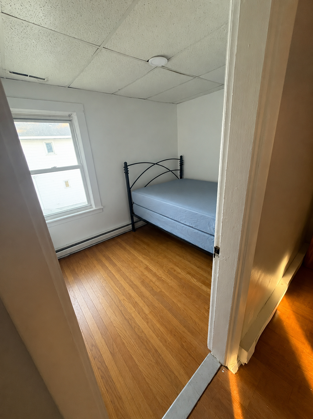 Private bedroom with bed and hardwood floors